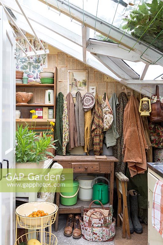 Gardening clothes and watering cans in Seaview Cottage, Cornwall, UK