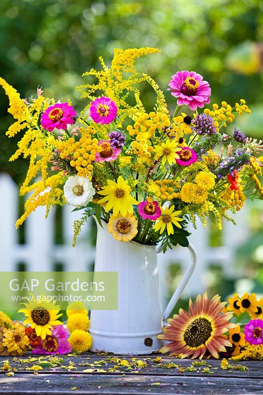 Jug of summer flowers: sunflowers, Zinnias, Verbena bonariensis, Rudbeckia, Solidago, Chrysanthemum and Tanacetum vulgare.