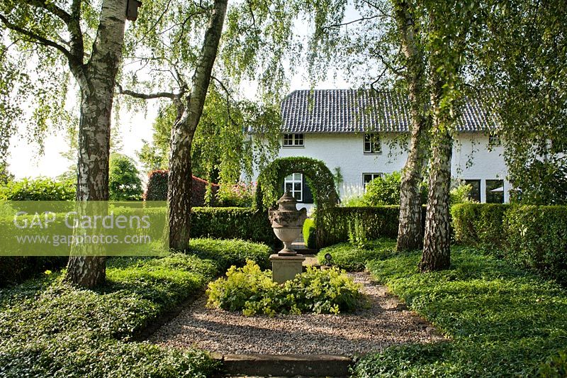 Birch grove with shady plantings and central decorative urns. De Carishof garden, July