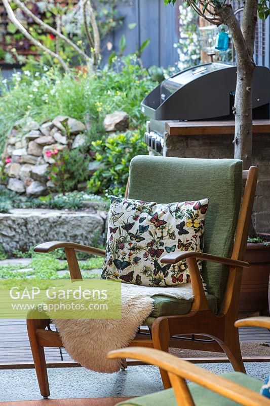 Chair with cushion and sheepskin in home of dancer, Fiona Jopp with view to  inner city courtyard garden