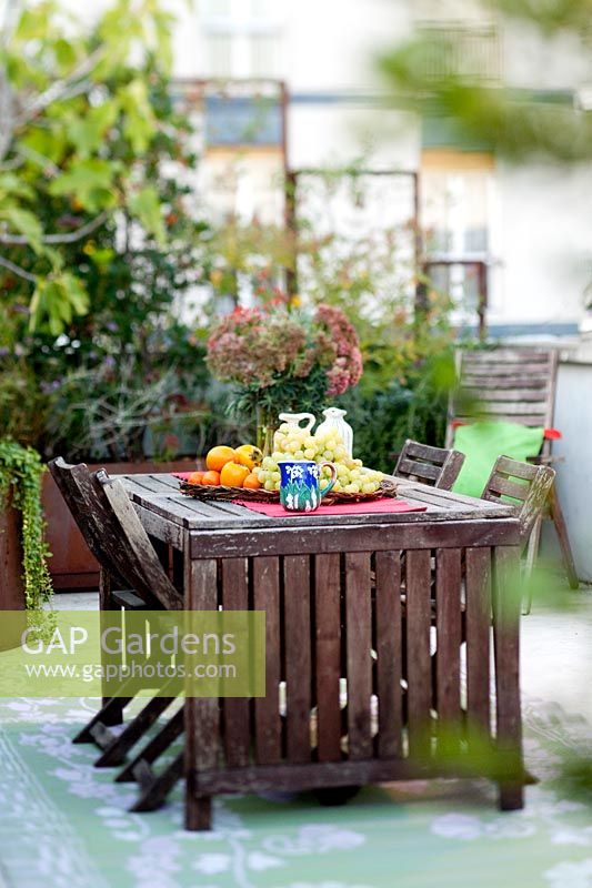 Outdoor table set with fruit surrounded by Garden terrace plants