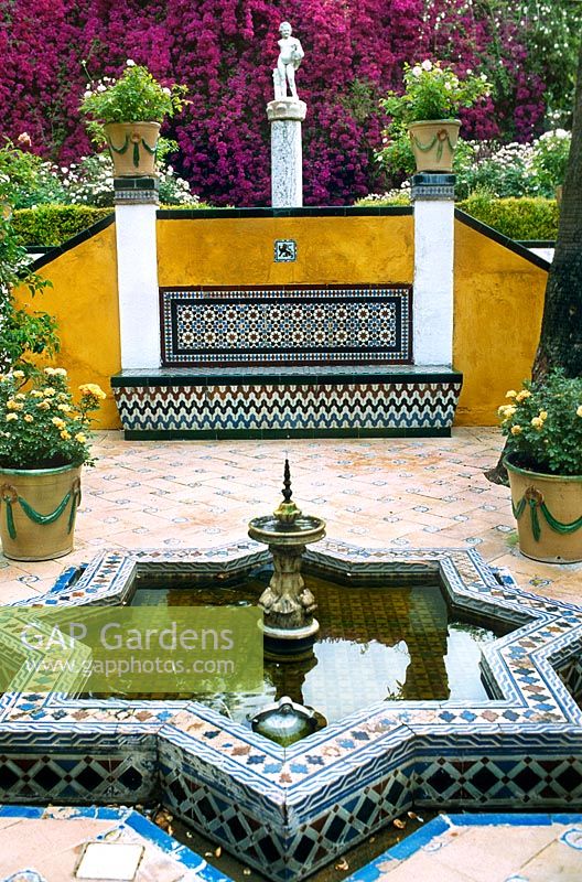 Moorish style fountain and pool with paving and mosaic wall decoration. Casa de Pilatos, Seville, Spain.