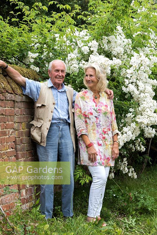 The late Major Iain Grahame with his wife, Bunny Campione, beside Rosa 'Rambling Rector' in their country garden at Daws Hall, Suffolk.