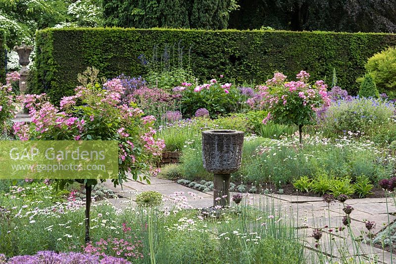 Sylvia's Garden at Newby Hall, a sunken, formal layout of beds with Byzantine stone corngrinder, July.