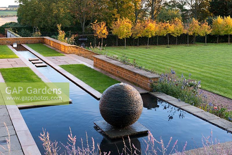 Long terrace rill ending in pool with slate sphere water feature created by sculptor James Parker.