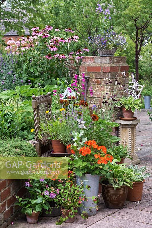 A container collection with annuals and perennials alongside a raised bed.
