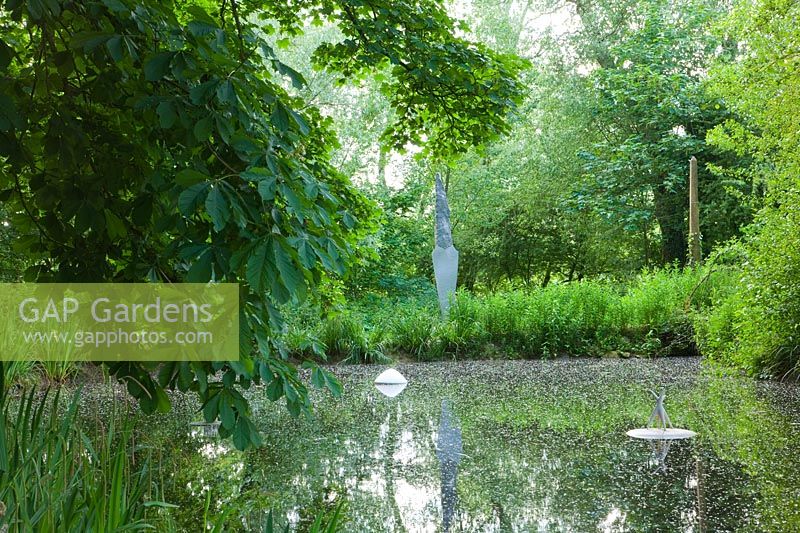 Pond with modern sculpture - Asthall Manor, Oxfordshire