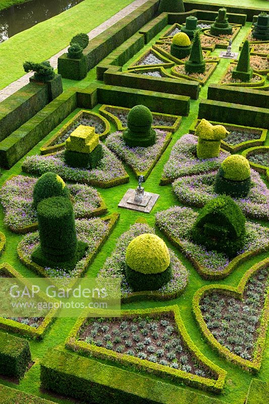 View over formal parterre showing clipped and shaped topiary and hedging
