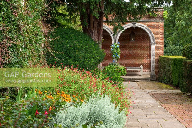 View along path to brick summerhouse with flower border
