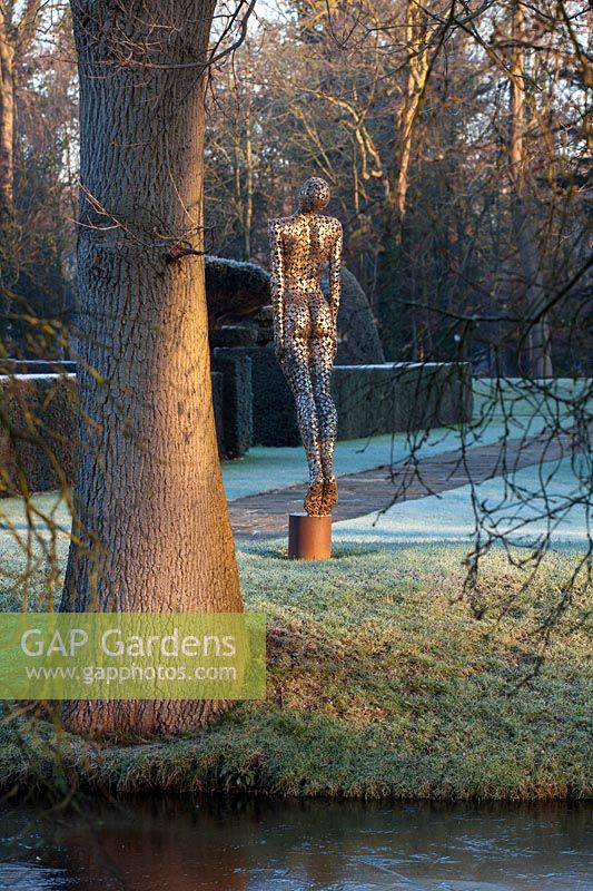 Sculpture of a soaring figure in stainless steel by Rick Kirby beside the moat 