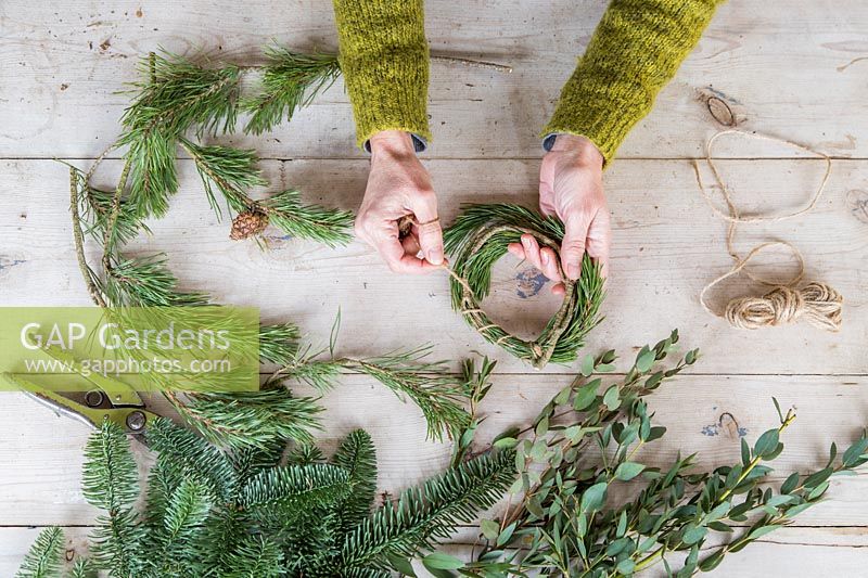 Using string to make a wreath from foliage