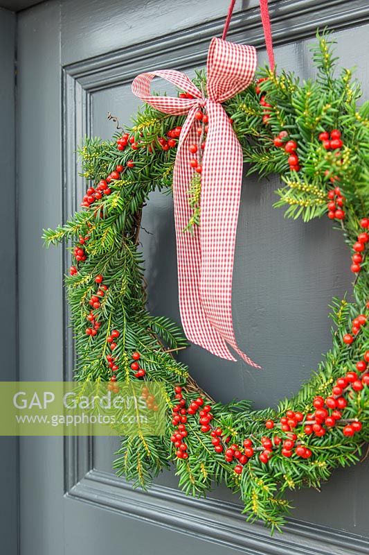 Festive Christmas wreath hanging on a wooden door