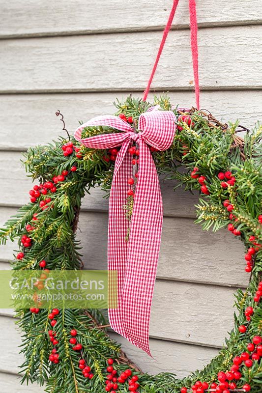 Festive Christmas wreath hanging in a rustic setting on a frosty morning