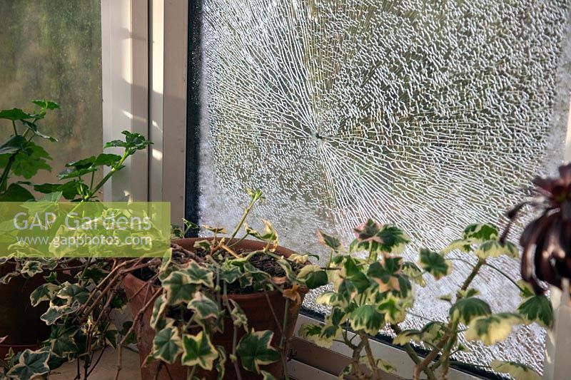 Broken conservatory window caused by stone thrown up by rotary mower
