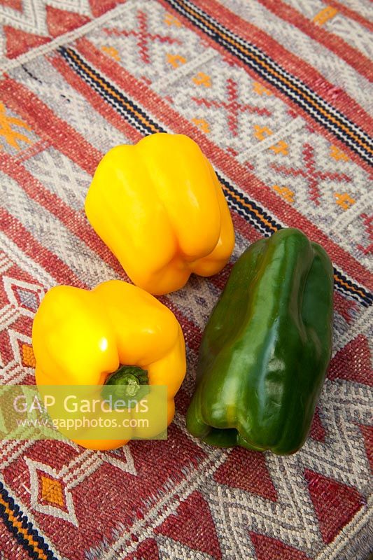 Colourful fresh vegetables - - Yellow and green peppers on a kilim covered table