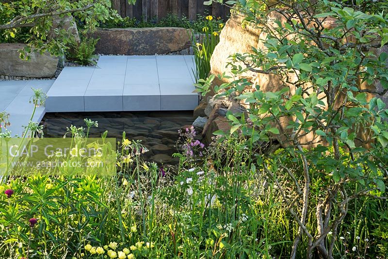 Sunken terrace and pool in grey sandstone. The M and G Garden, RHS Chelsea Flower Show 2016. Designer Cleve West. Gold Medal winner