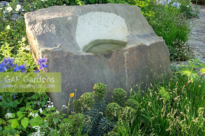 Rough sandstone boulder with bird bath in The M and G Garden, RHS Chelsea Flower Show 2016. Designer Cleve West. Gold Medal winner