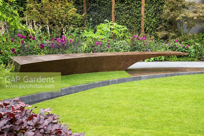 Curving path, seat and borders in The Chelsea Barracks Garden at the RHS Chelsea Flower Show 2016. Designer: Jo Thompson.