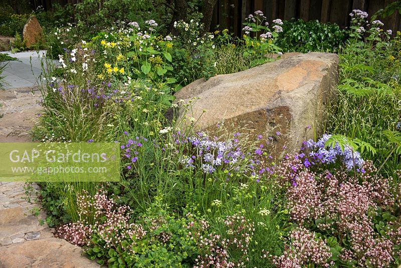 Woodland planting and sandstone boulder in The M and G Garden, RHS Chelsea Flower Show 2016. Designer Cleve West. Gold Medal winner