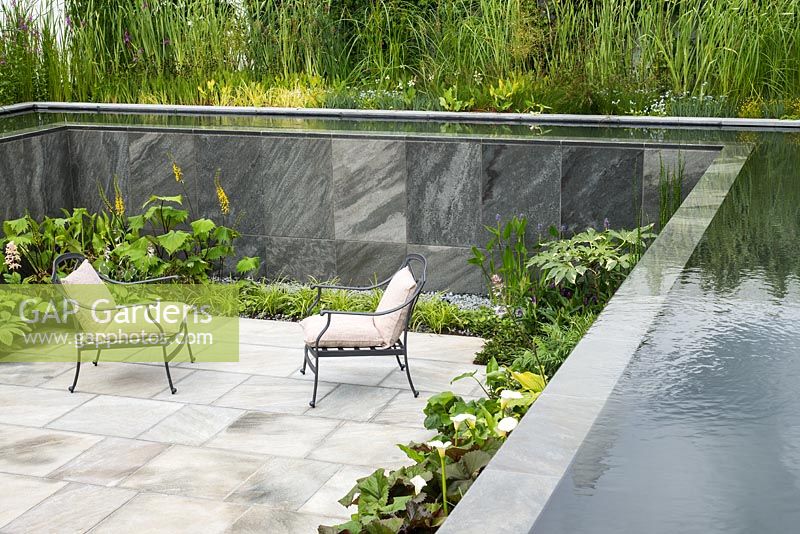 Paved sunken garden with seats, pool and cascading water walls. Private protected garden space. RHS Hampton Court Flower Show