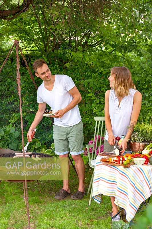 Young couple barbecueing in the garden