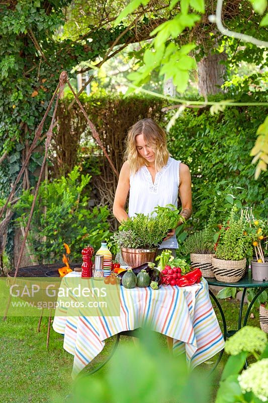 Young woman is barbequeing in the garden