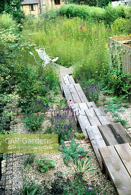 Urban meadow garden with wooden deck steps deck patio with seating