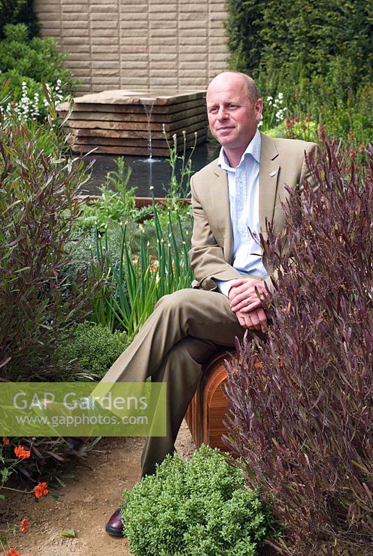 Homebase Teenage Cancer Trust Garden designer Joe Swift sitting in his garden at the RHS Chelsea Flower Show 2012