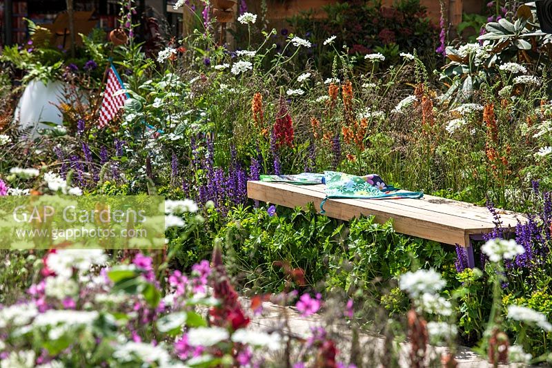 Colorful perennial garden with wooden bench