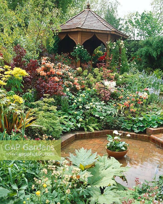 Pond with flowering perennials, ornamental shrubs and Rhododendron
