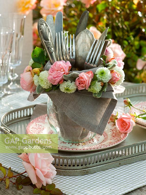 Cutlery in glass vase with napkin ring of pink ( roses )