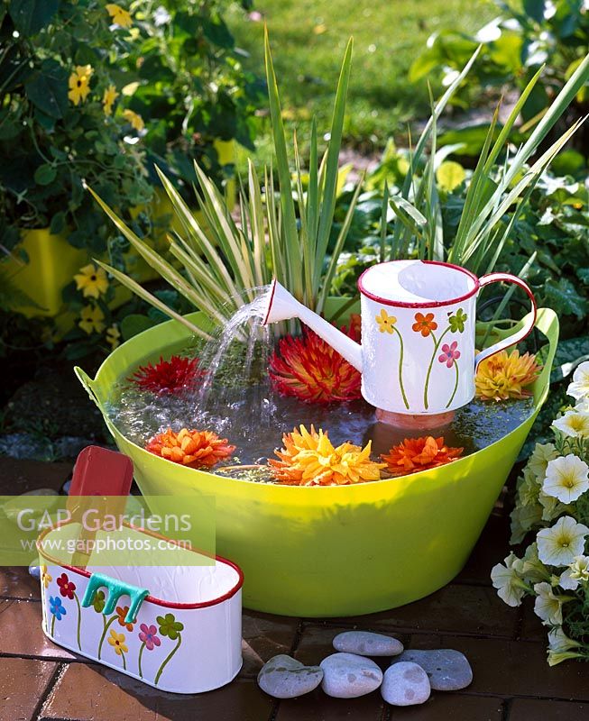 Small water feature with mini watering can and plastic tub