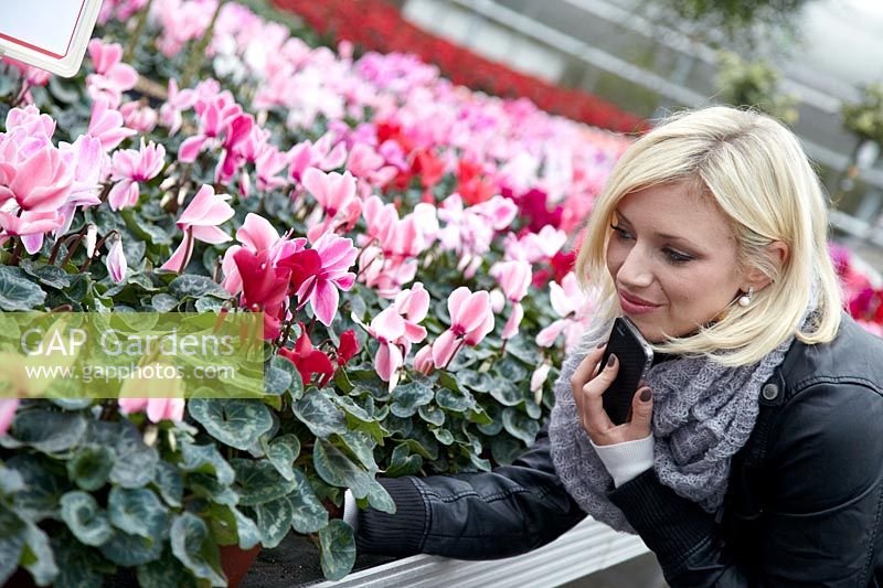Young woman in the garden center scanning the QR code