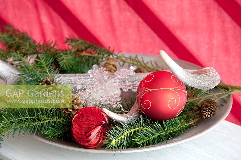 Christmas decoration with ornaments, brushwood, cones and antlers