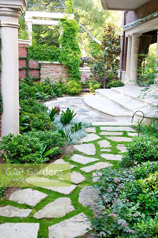 Stone walkway with shrubs and perennials, columns and marble stairs