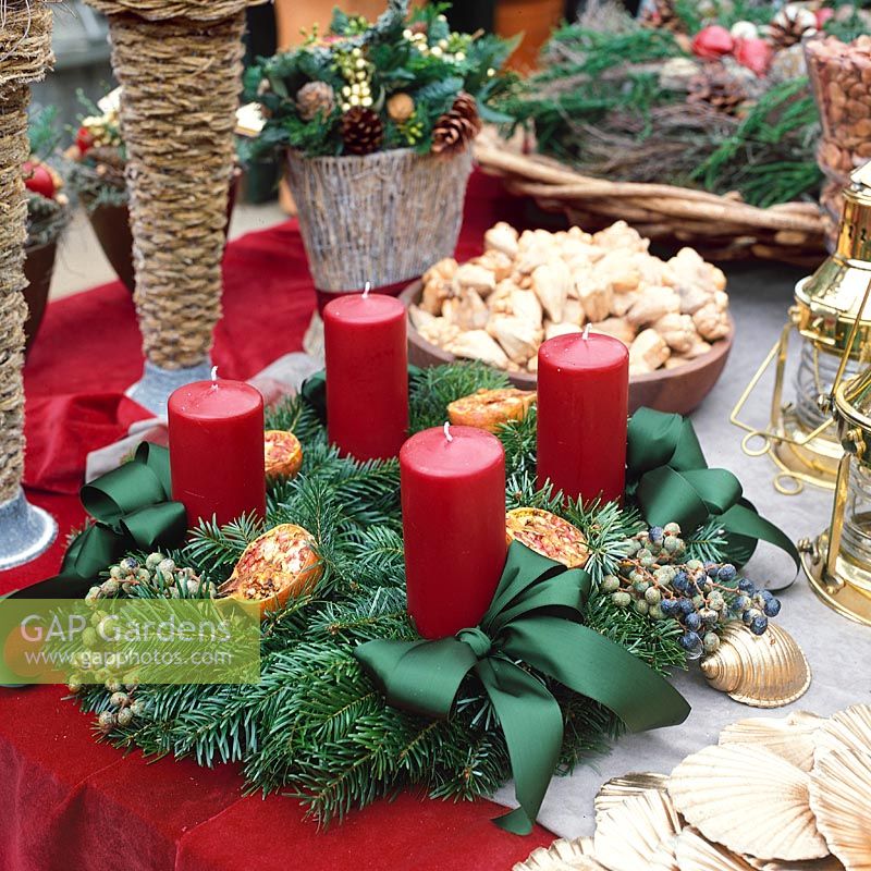 Adventskranz mit roten Kerzen und grünen Dekorschleifen