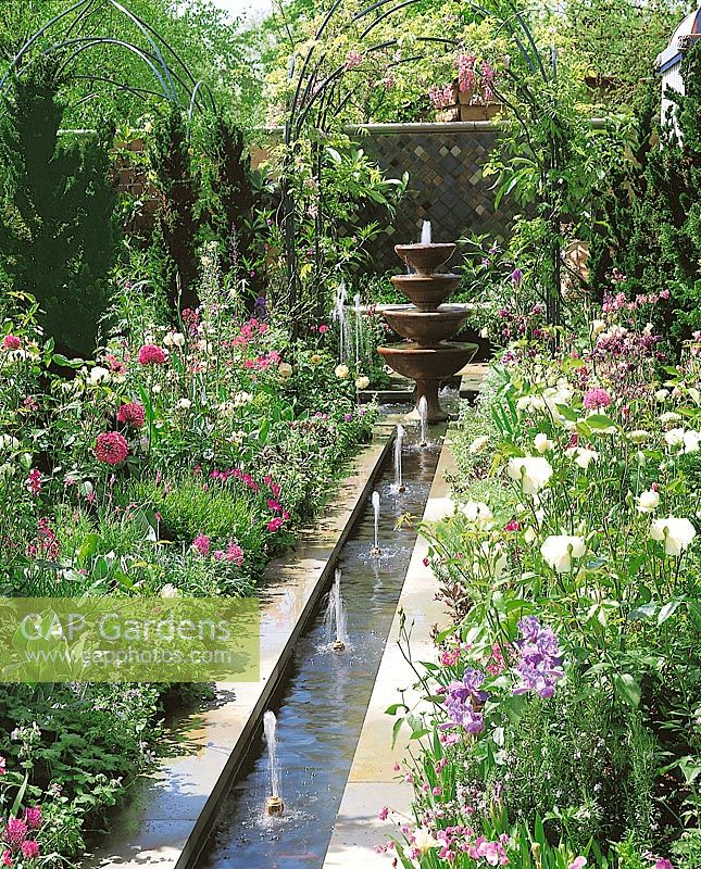 Gartenarchitektur mit Springbrunnen und Blütenstauden