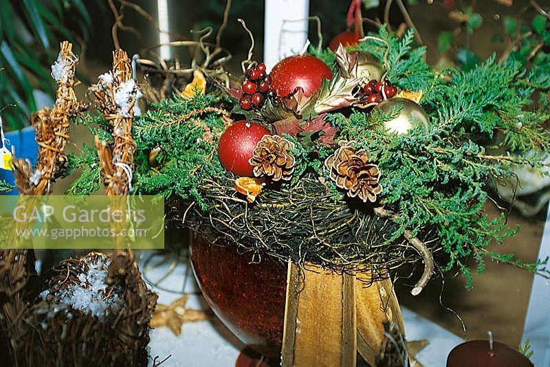 Adventsgesteck mit roten und goldenen runden Kerzen