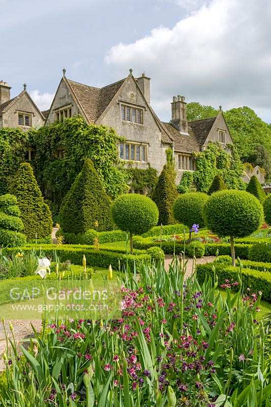 Abbey House Garden, Wiltshire, UK. Early summer, view of the Manor House across the knot garden