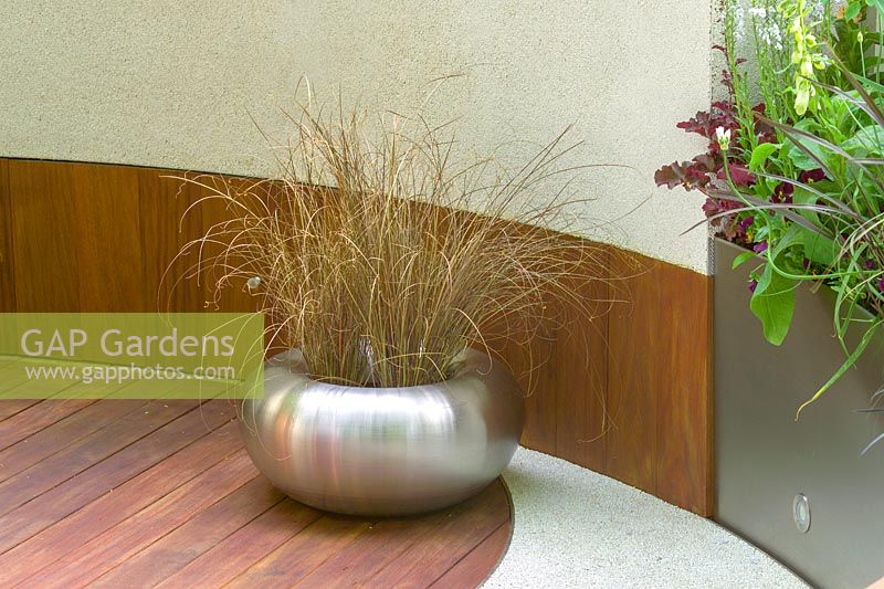 The Chelsea Flower Show 2005, London, UK. 'Urban Space:Modern Eden' ( Kate Gould ) mixed materials and textures, metal container with grass planting, wooden decking and curved wall