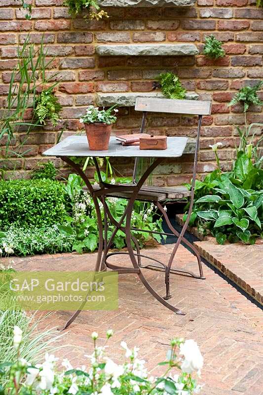 Chelsea Flower Show, 2009. 'Jacob's Ladder' garden ( des. Jeff Hewitt ) simple elegant table and chair in small courtyard garden with brick paving