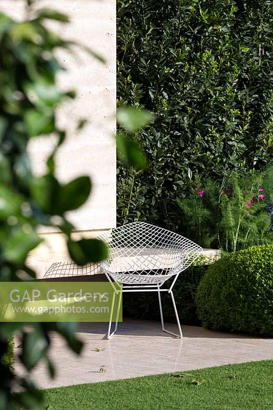 RHS Chelsea Flower Show 2014. The Telegraph Garden, designer Tommaso Del Buono. Elegant metal chair in modern garden. 