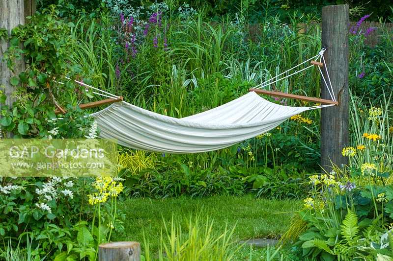 Hampton Court Flower Show, 2004. 'Lazy Days' ( des. Pete Simms ) hammock in informal and natural garden
