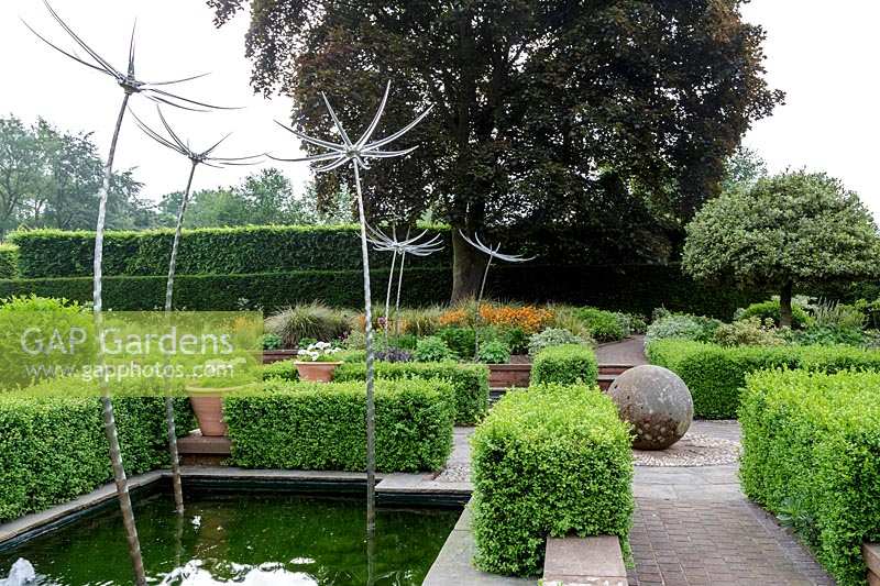 Mitton Manor, Staffordshire. Formal garden parterre with Neil Wilkin glass 'Suncatcher' sculptures