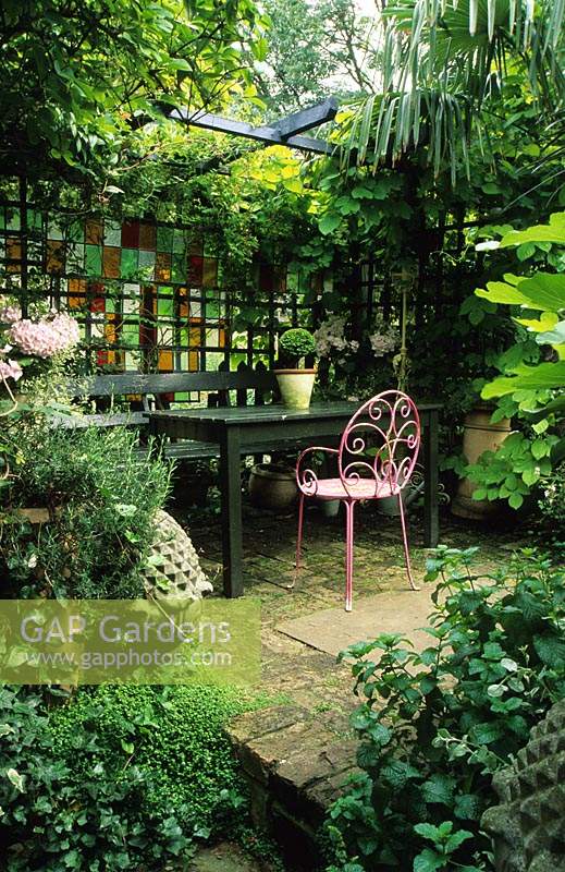 Private garden London Design Jonathan Baillie Shady garden Covered seating area Pink painted chair
