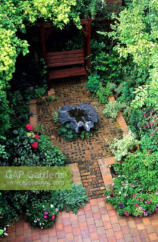 private garden Manchester design Alan Titchmarsh overview of small suburban town patio garden with brick and tile paving covered