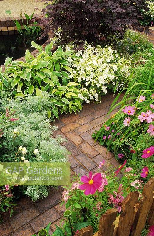 zig zag meandering brick path with flower borders either side