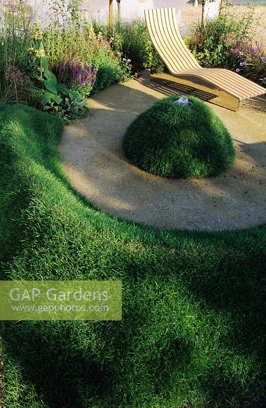 Hampton Court FS 2001 Design Nicholas Howard Sculptural lawn mounds in small town garden with reclined seat