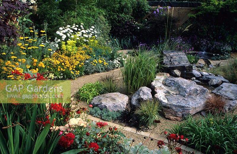 Feng Shui garden London Design Pamela Woods curved sinuous cobble path gravel alpine rock area with circular pond water feature
