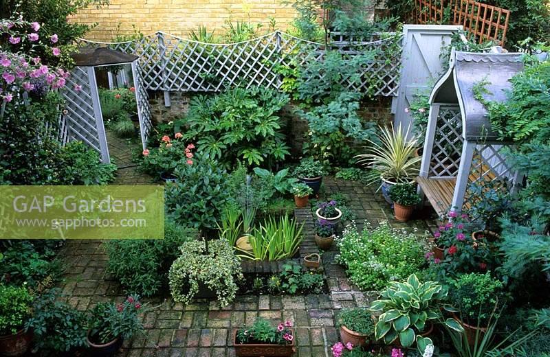 private garden London design Pamela Woods small town suburban patio garden with formal pond covered seat containers trellis mirr